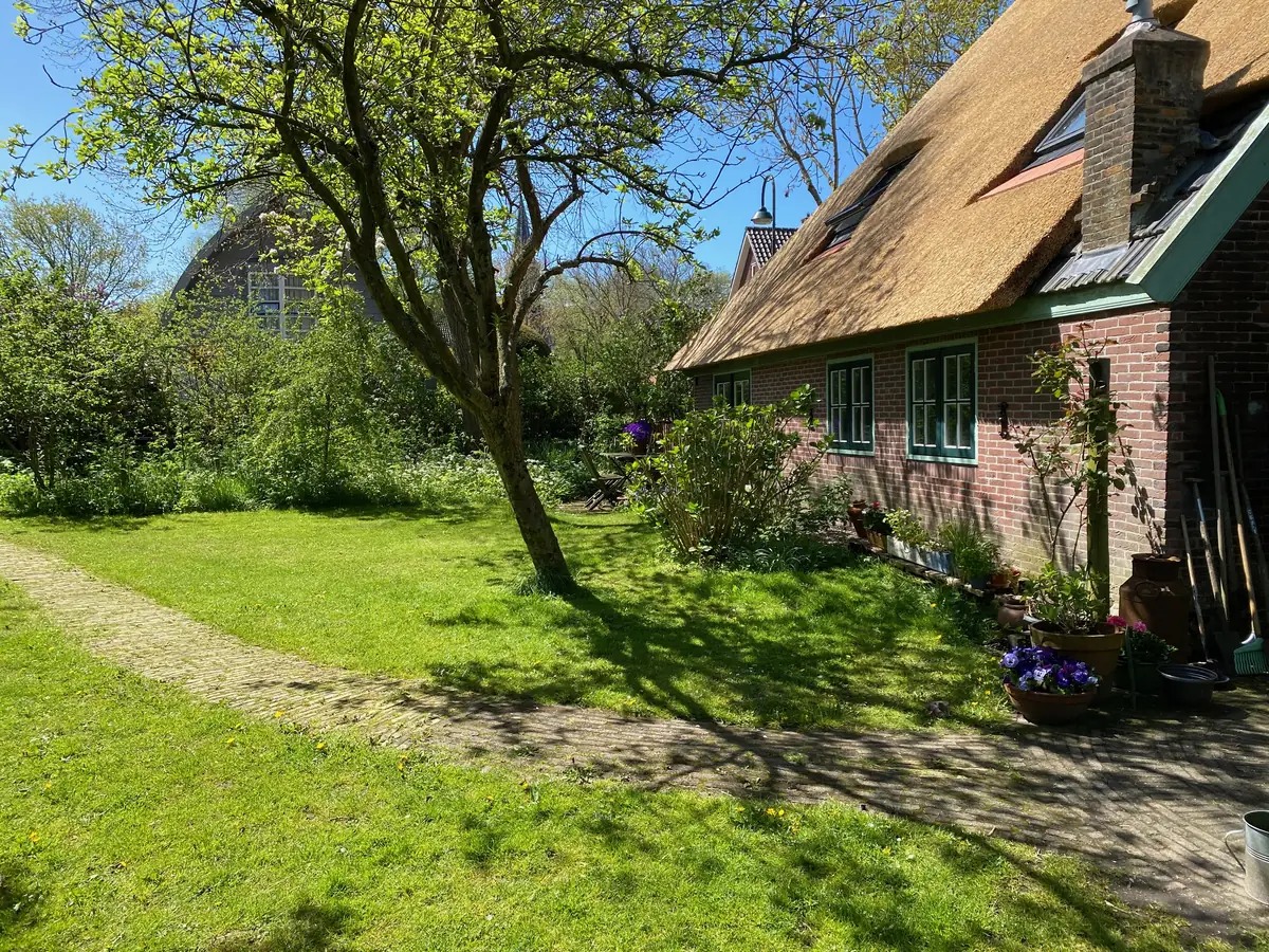 De stolpboerderij vanuit de tuin