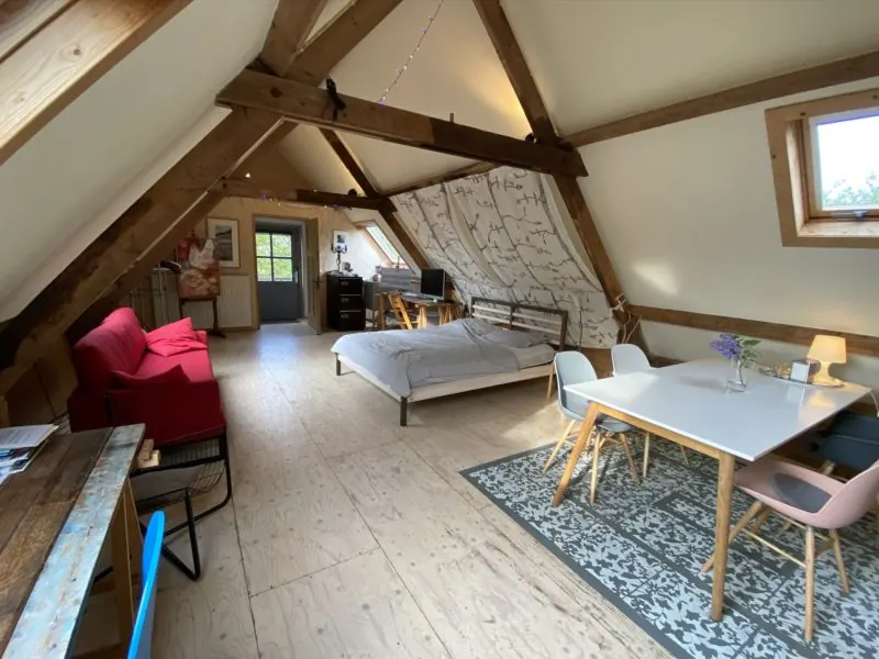 Overzicht van Atelier aan Zee: zithoek, bed en eettafel
